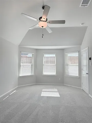an empty room with windows and fan