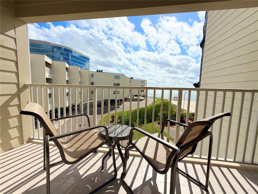 2506 North Rocky Point Drive, Unit 305 Tampa, FL 33607 - Photo 4 of 13 a view of a balcony with chairs and wooden floor