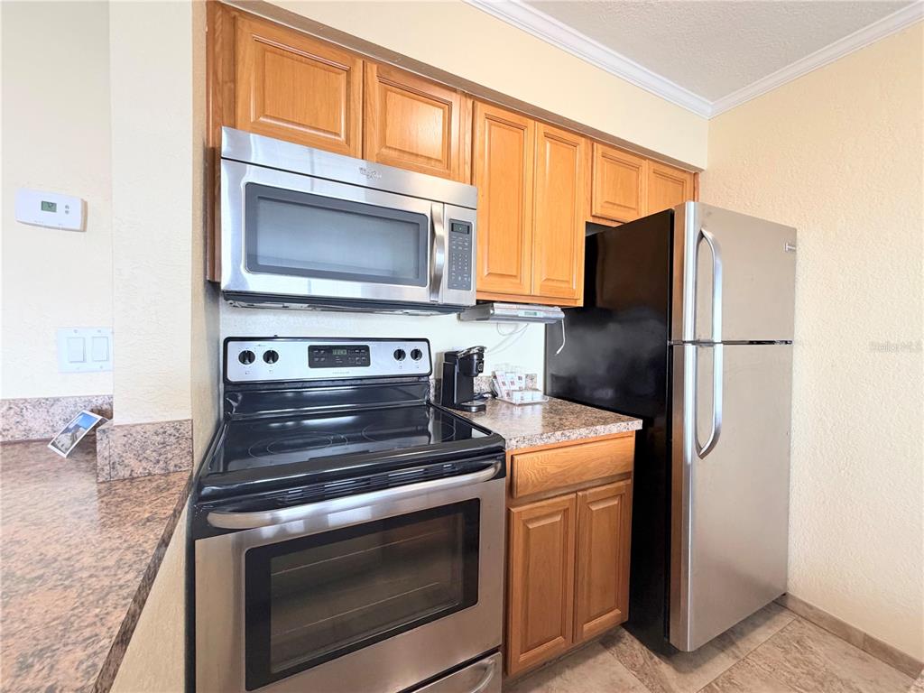 2506 North Rocky Point Drive, Unit 305 Tampa, FL 33607 - Photo 7 of 13 a kitchen with stainless steel appliances granite countertop a stove microwave and refrigerator