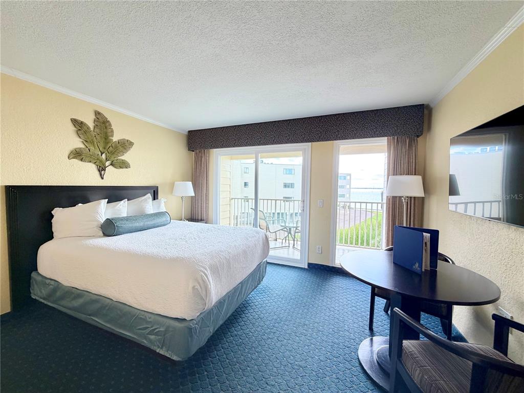 2506 North Rocky Point Drive, Unit 305 Tampa, FL 33607 - Photo 9 of 13 a bedroom with a large bed and a desk