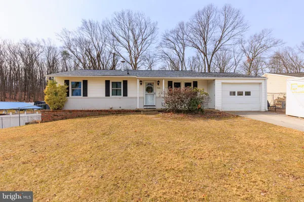 a front view of house with yard and trees around