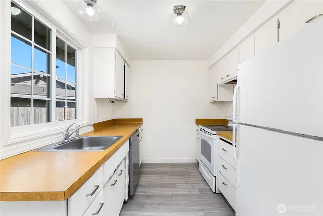 a kitchen with granite countertop a sink a stove and refrigerator