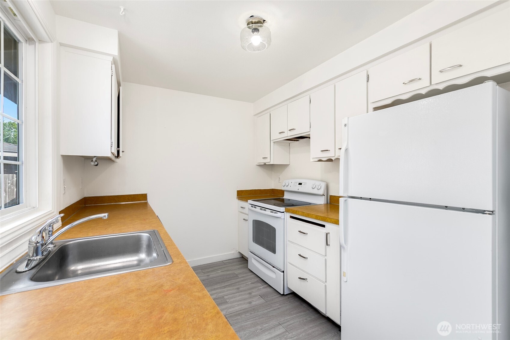 15028 108th Place Northeast Bothell, WA 98011 - Photo 13 of 26 a kitchen with white cabinets and white appliances