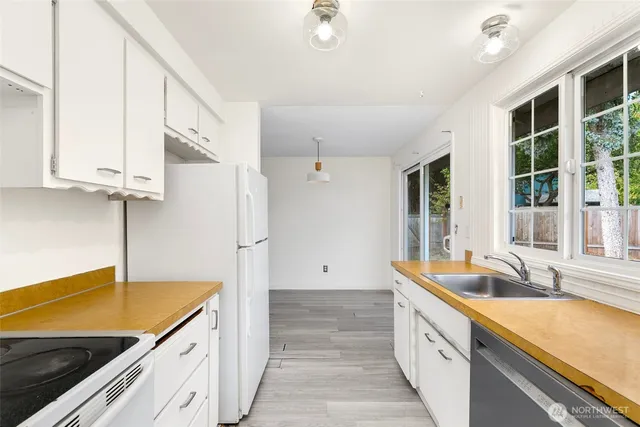 a kitchen with granite countertop a sink and a refrigerator