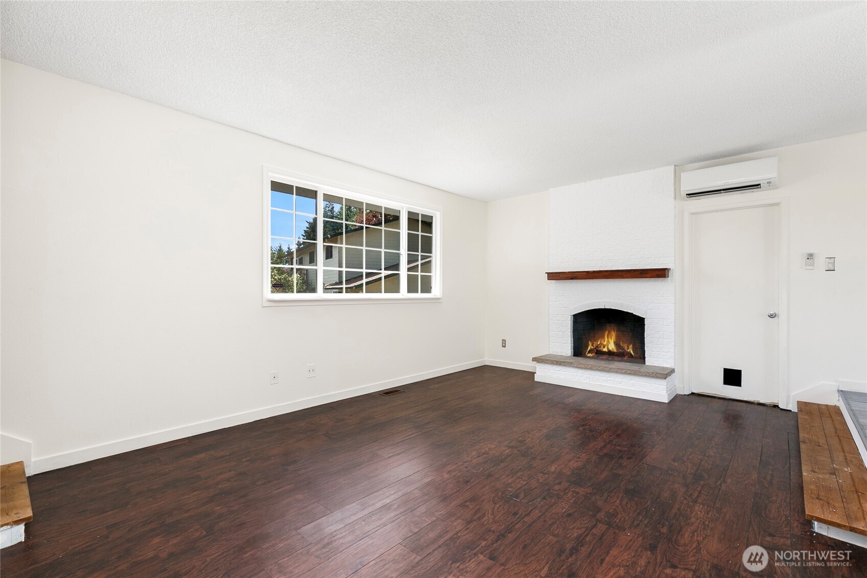 15028 108th Place Northeast Bothell, WA 98011 - Photo 5 of 26 a view of empty room with wooden floor and fireplace