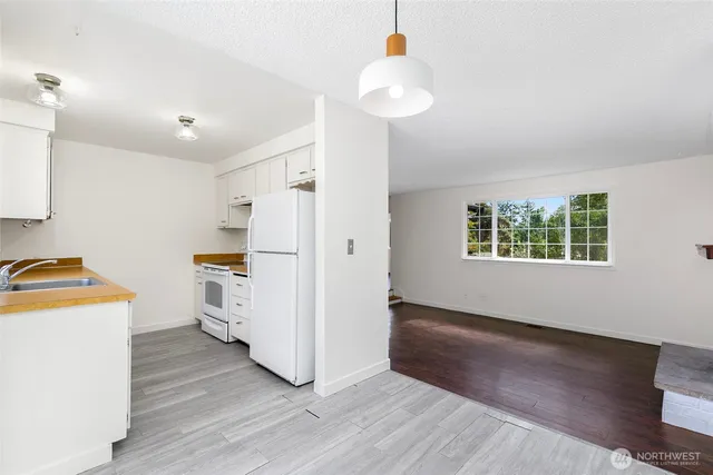a view of a kitchen with wooden floor and electronic appliances