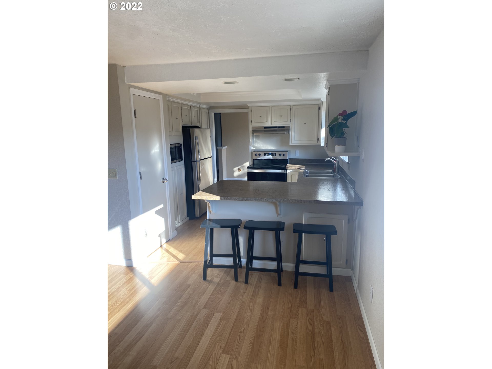 1023 65th Street Springfield, OR 97478 - Photo 5 of 23 a kitchen with a dining table chairs and a refrigerator