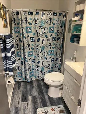 a bathroom with a toilet and a shower curtain