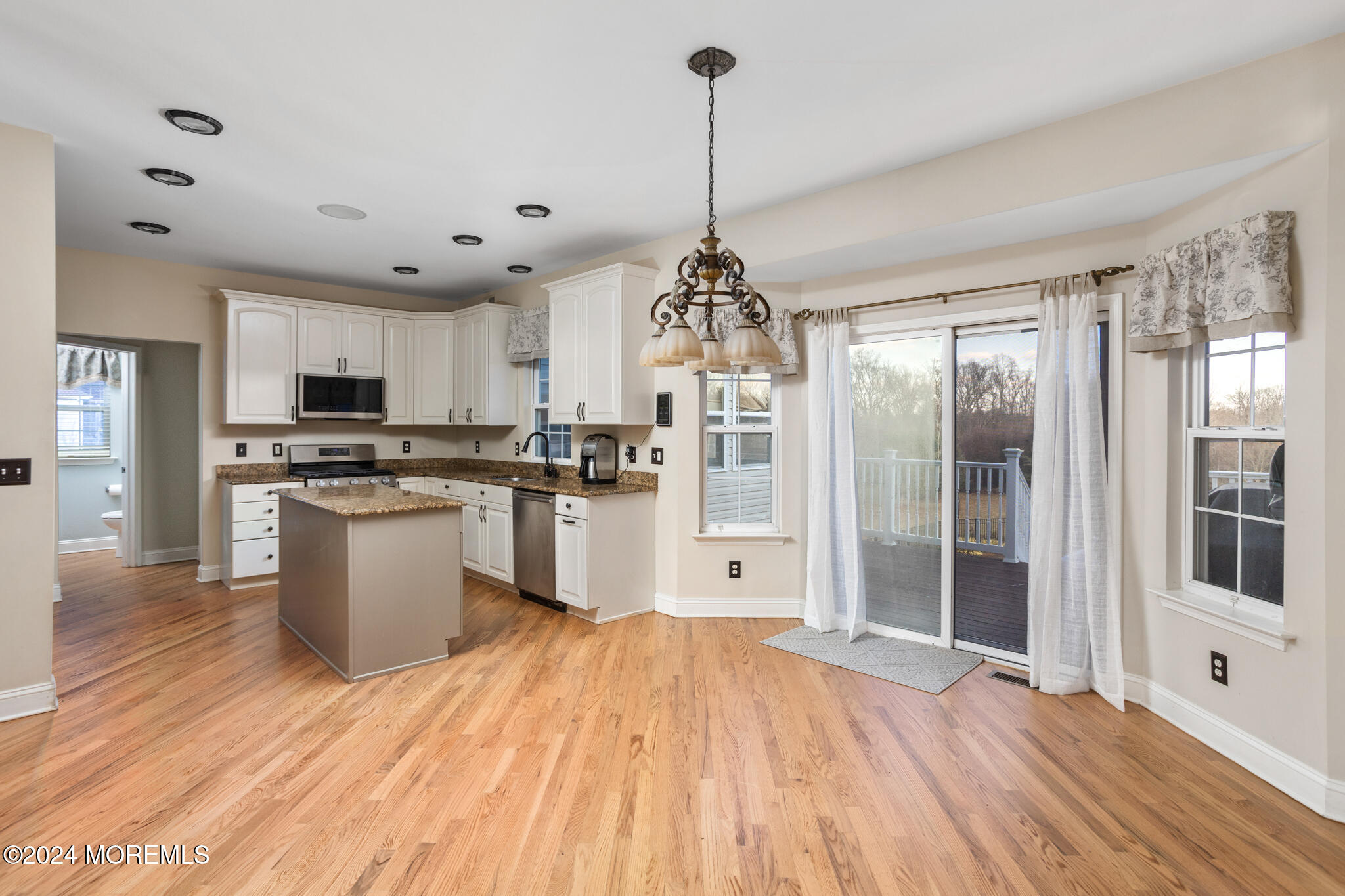 115 Holmes Mill Road Cream Ridge, NJ 08514 - Photo 9 of 49 a open kitchen with granite countertop a stove top oven a sink dishwasher a dining table and chairs with wooden floor