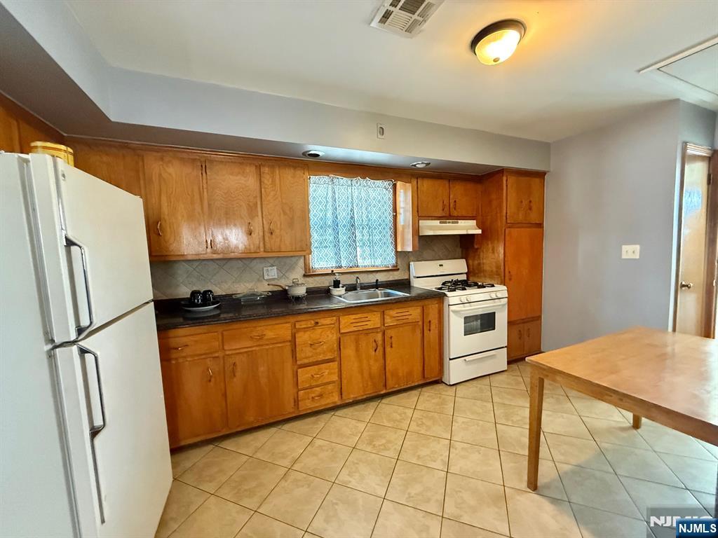 749 Cleveland Avenue, Unit 2 Harrison, NJ 07029 - Photo 3 of 16 a kitchen with granite countertop a refrigerator stove top oven and sink