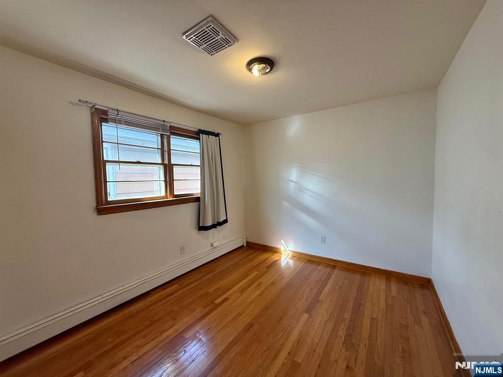 749 Cleveland Avenue, Unit 2 Harrison, NJ 07029 - Photo 10 of 16 an empty room with wooden floor and windows