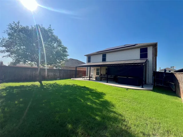 a view of house with backyard and a slide