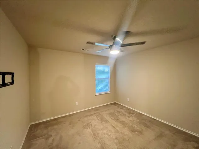 an empty room with closet and a chandelier fan