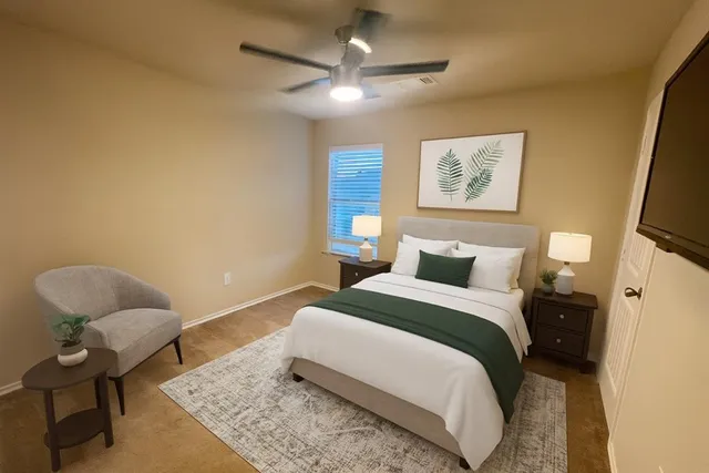 an empty room with windows and fan