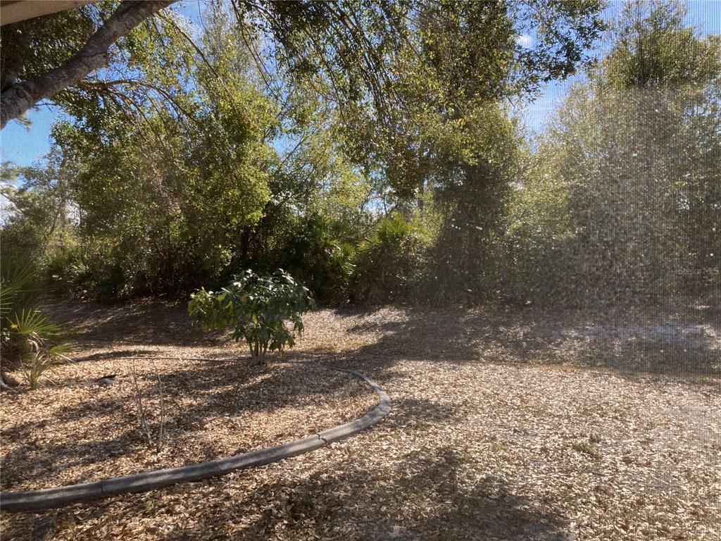 1088 Nomad Road Punta Gorda, FL 33983 - Photo 13 of 13 a view of a yard with plants and trees
