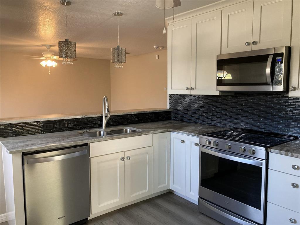 1088 Nomad Road Punta Gorda, FL 33983 - Photo 3 of 13 a stove top oven sitting inside of a kitchen