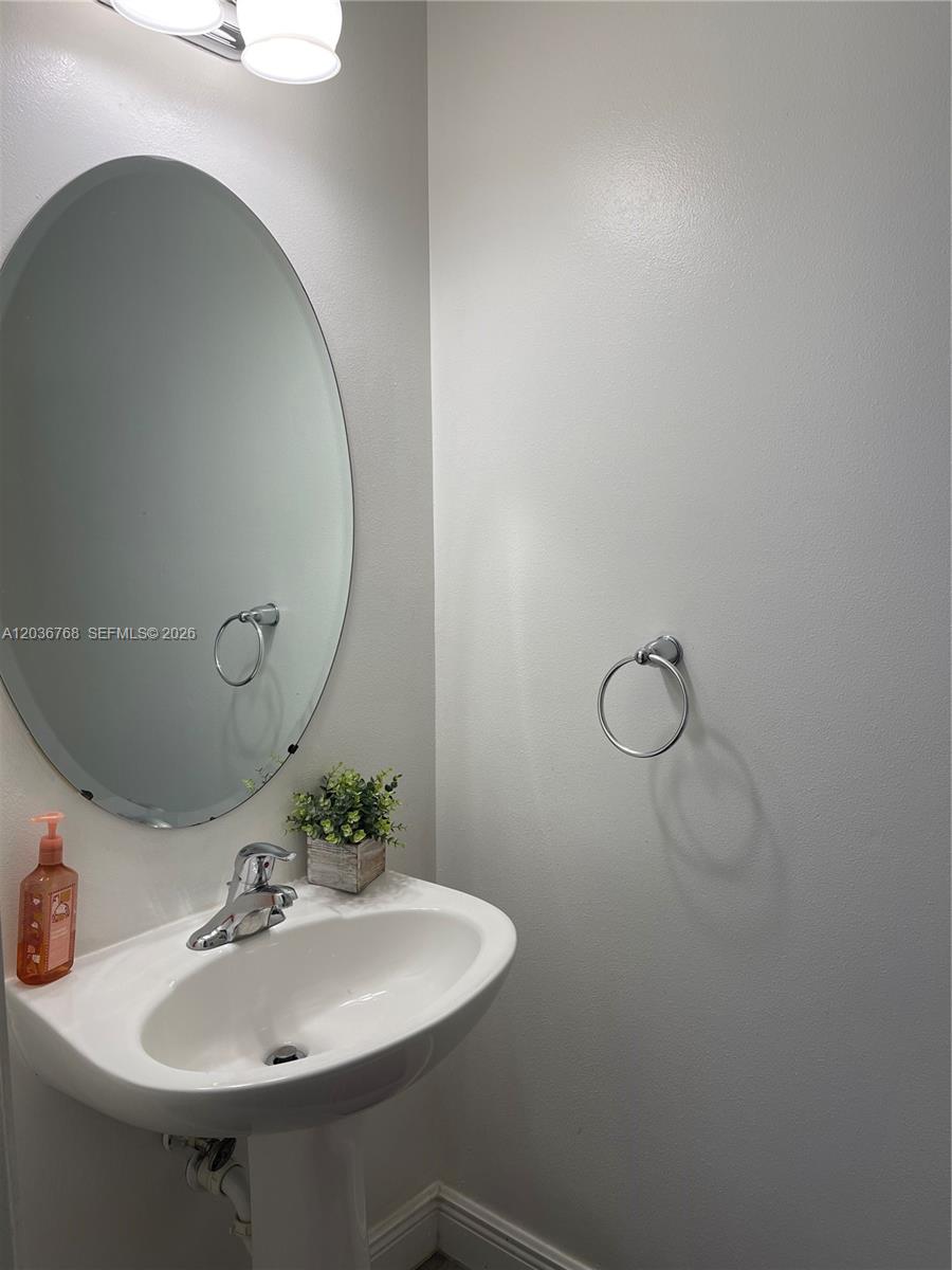 2432 Southwest 99th Way Miramar, FL 33025 - Photo 9 of 17 a bathroom with a sink and mirror