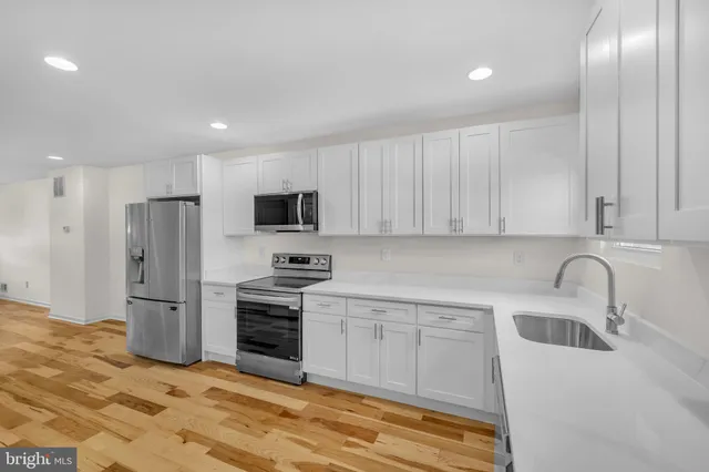 a kitchen with a sink stainless steel appliances and cabinets