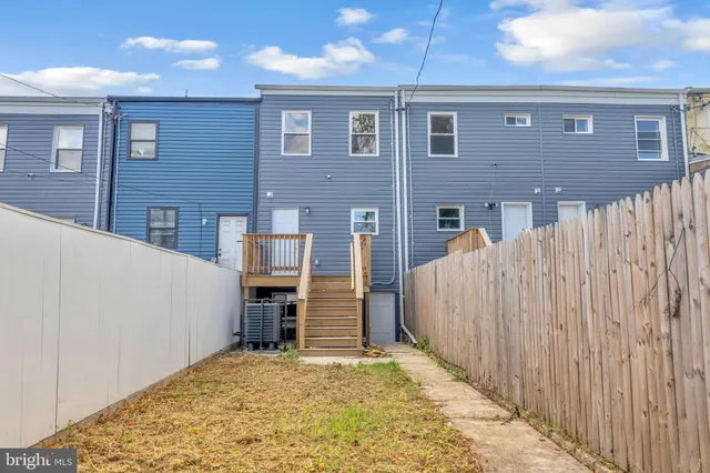 a view of a brick house with a wooden fence