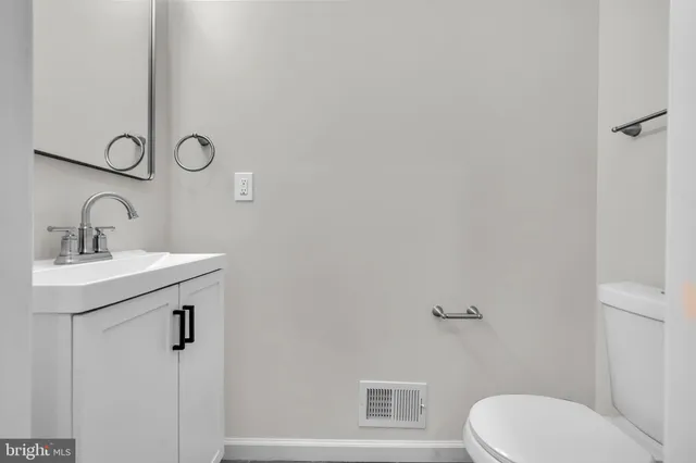 a bathroom with a granite countertop toilet sink and mirror