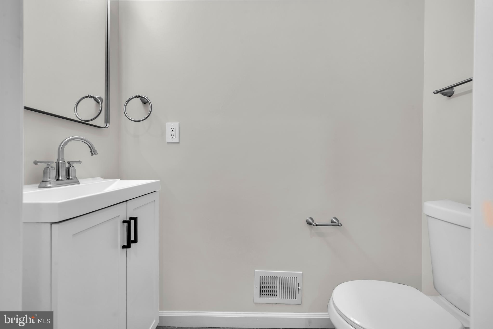 1626 Hazel Street Curtis Bay, MD 21226 - Photo 6 of 24 a bathroom with a granite countertop toilet sink and mirror