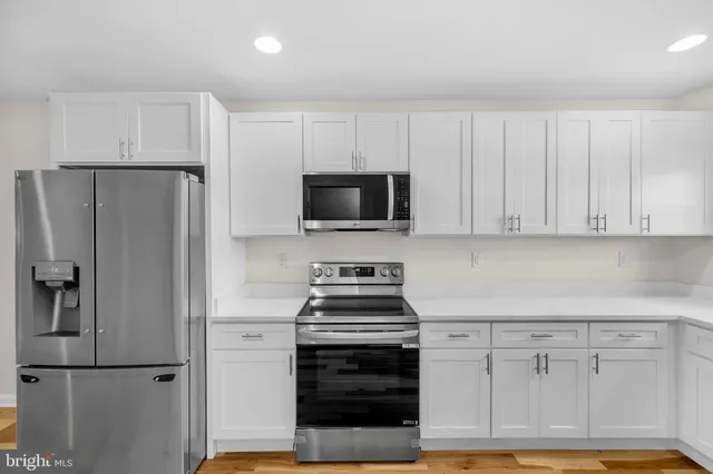 a kitchen with white cabinets and stainless steel appliances