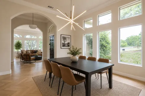 a view of a dining room and livingroom with furniture wooden floor a chandelier