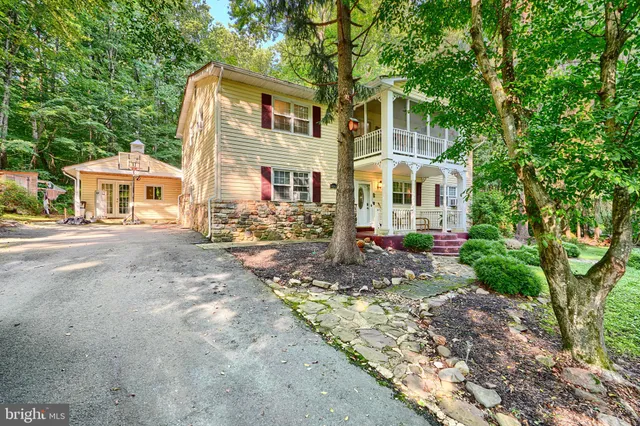 a front view of a house with a yard and trees