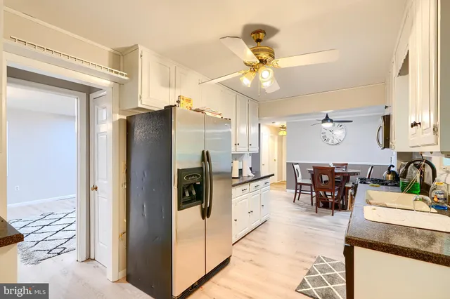 a kitchen with stainless steel appliances kitchen island granite countertop a refrigerator a sink a stove and island