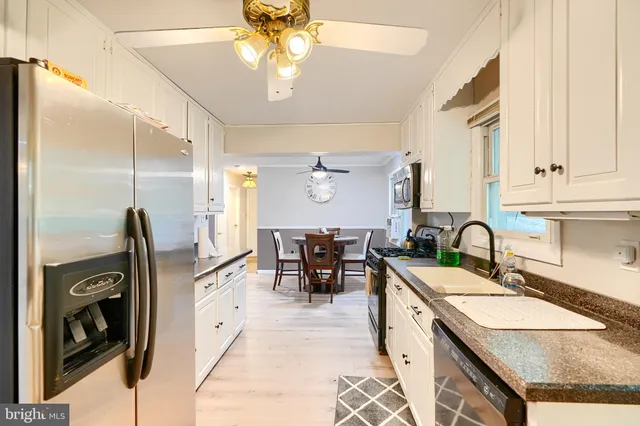 a kitchen with granite countertop a sink a counter top space appliances and cabinets