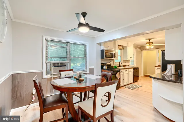 a dining room with furniture a chandelier and wooden floor