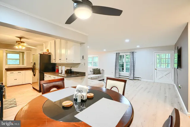 a living room with furniture kitchen view and a large window