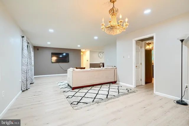 a living room with furniture a chandelier and a window