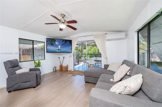 a kitchen with stainless steel appliances a kitchen island hardwood floor sink stove dining table and chairs