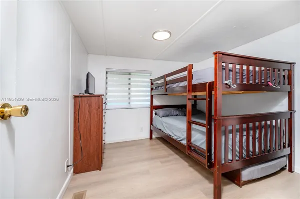 a view of a bedroom with wooden floor and windows