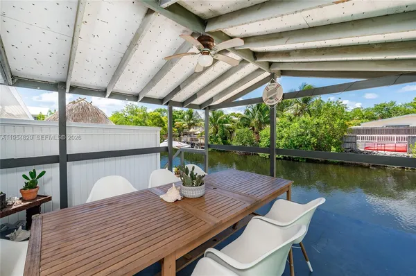 a view of a chairs and table in patio with wooden floor
