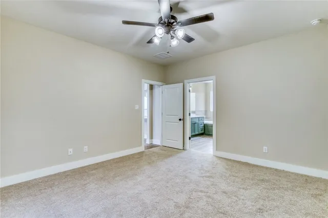 an empty room with fan and a ceiling fan