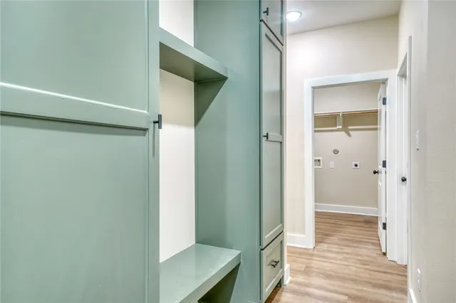 a view of a hallway with wooden floor and staircase