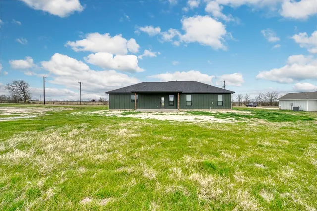 a backyard of a house with table and chairs
