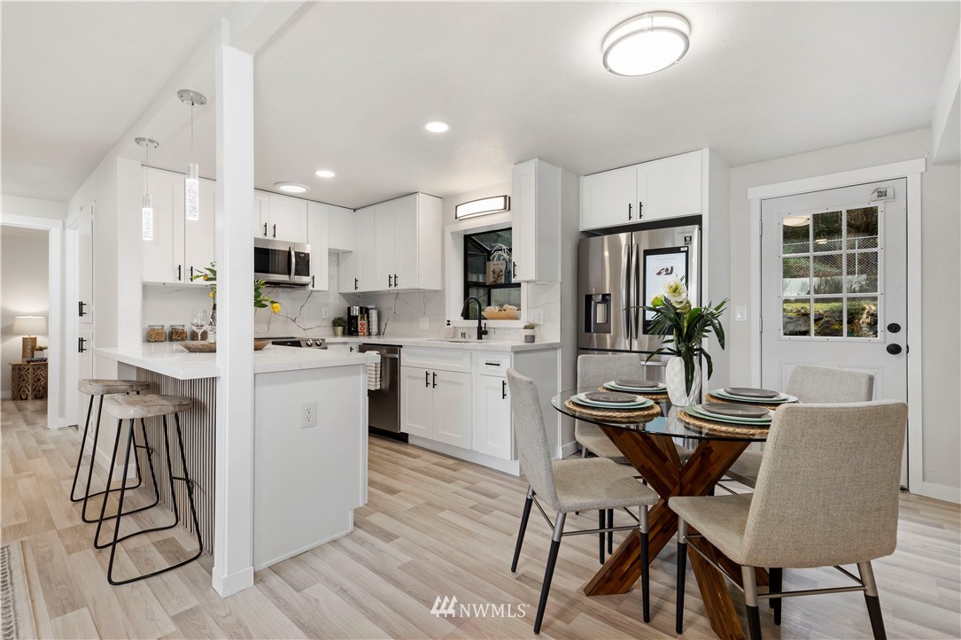 3012 Southwest 102nd Street Seattle, WA 98146 - Photo 13 of 32 a kitchen with a dining table chairs and refrigerator