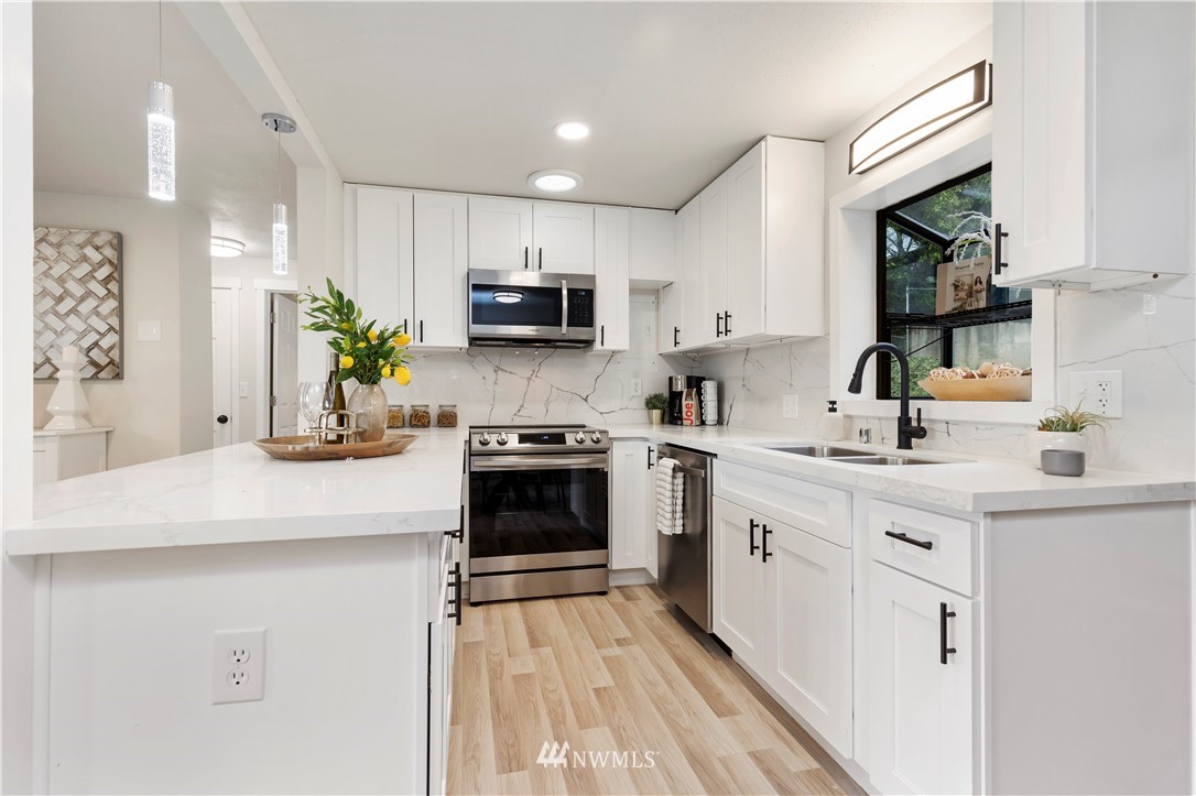 3012 Southwest 102nd Street Seattle, WA 98146 - Photo 17 of 32 a kitchen with kitchen island white cabinets and appliances