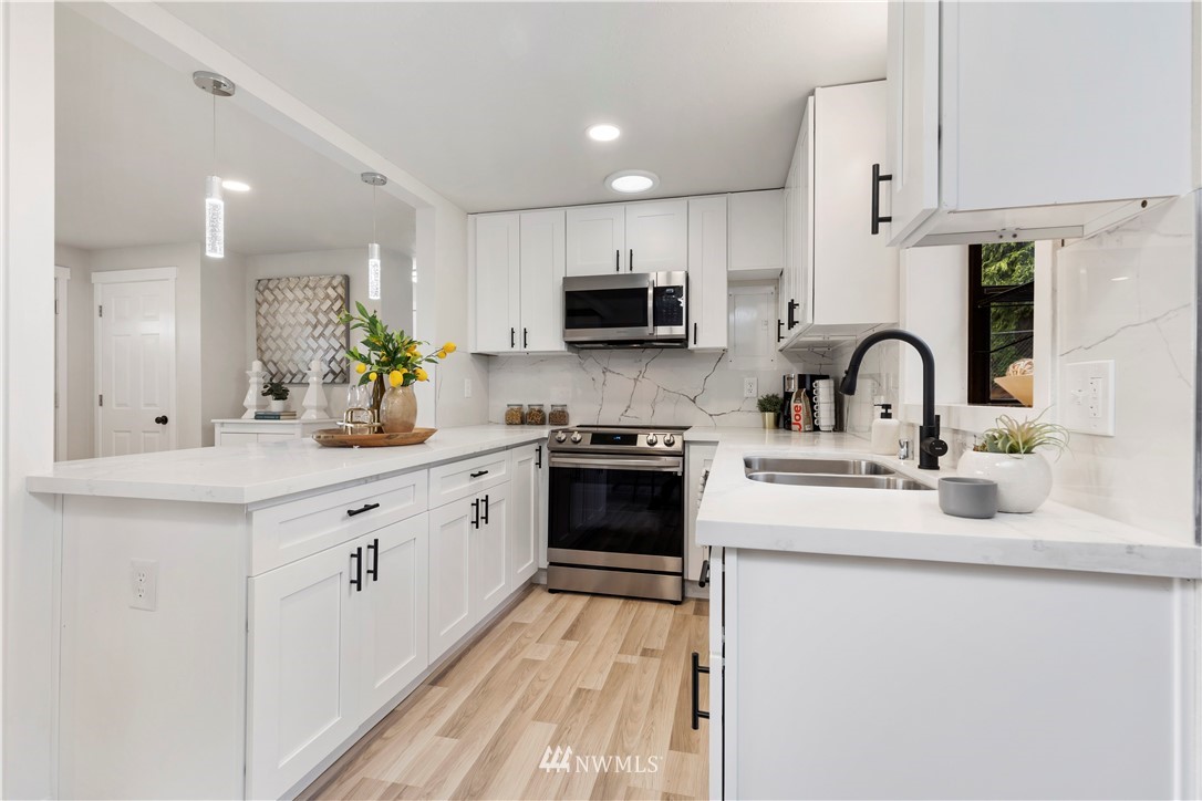 3012 Southwest 102nd Street Seattle, WA 98146 - Photo 18 of 32 a kitchen with granite countertop a sink and white appliances