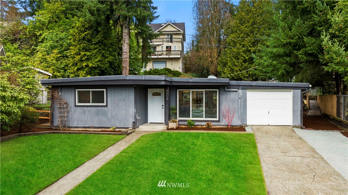 3012 Southwest 102nd Street Seattle, WA 98146 - Photo 2 of 32 a front view of a house with a yard and trees