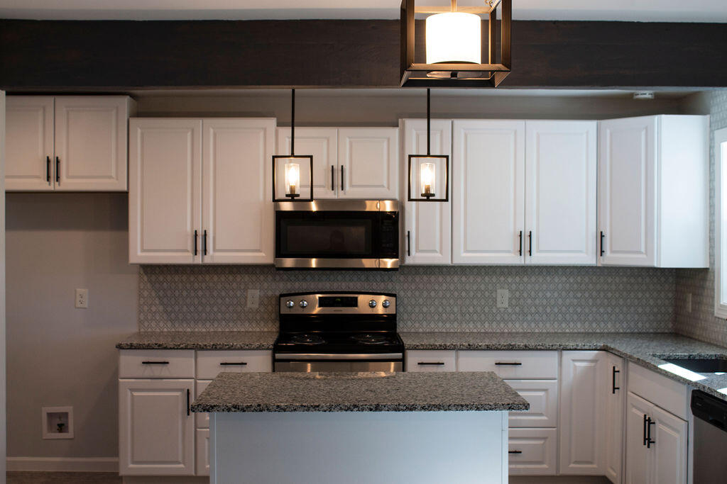 4438 Windsor Spring Road Hephzibah, GA 30815 - Photo 3 of 23 The kitchen has beautiful granite countertops, backsplash, and modern light fixtures.