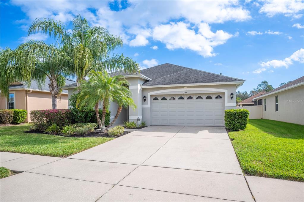 a front view of a house with a yard and garage