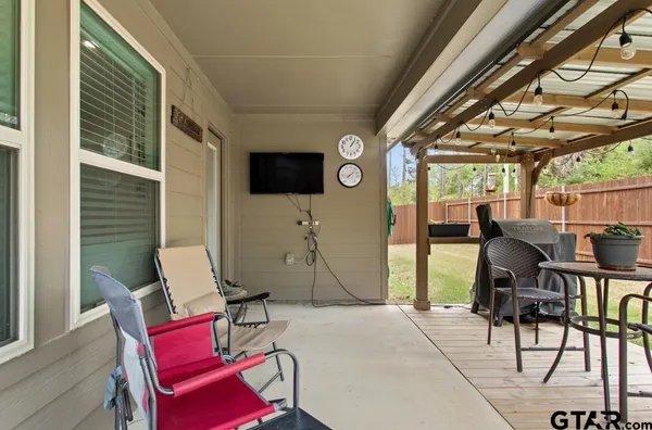 a living room with furniture a flat screen tv and floor to ceiling window