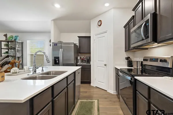 a kitchen with stainless steel appliances granite countertop a sink stove and refrigerator