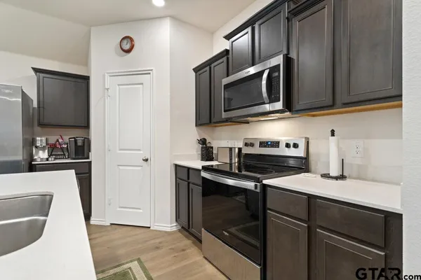 a kitchen with stainless steel appliances granite countertop a sink stove and microwave