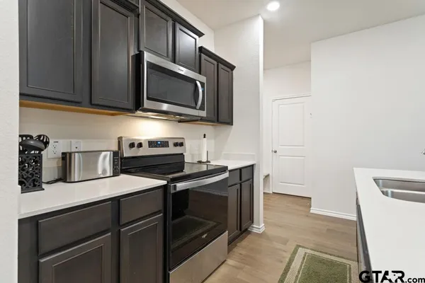 a kitchen with stainless steel appliances a stove microwave and sink