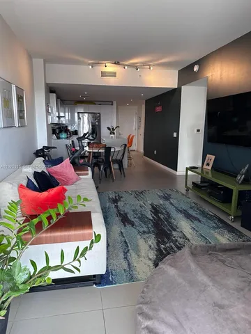 a living room filled with furniture and a flat screen tv
